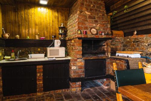 a brick kitchen with a microwave and a stove at Casa Soseco in Orşova