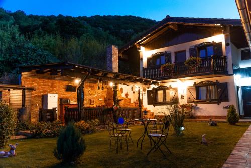 a house with chairs and a table in the yard at Casa Soseco in Orşova