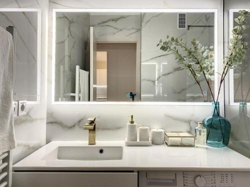 une salle de bain blanche avec un lavabo et un miroir dans l'établissement Modern flat Cannes Center, à Cannes