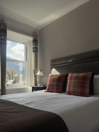 a bedroom with a large bed with a window at Creag Mhor Lodge in Onich