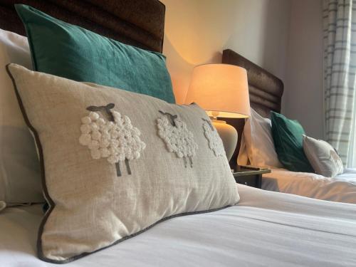 a pillow with two sheep on it on a bed at Creag Mhor Lodge in Onich