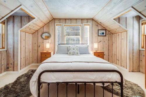 een slaapkamer met een groot bed in een kamer met houten wanden bij Alpine Cottage Hideaway in Stateline
