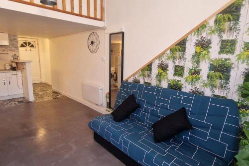 un divano blu in un soggiorno con una scala di Studio L'Occitan en plein centre ville avec balcon a Lézignan-Corbières