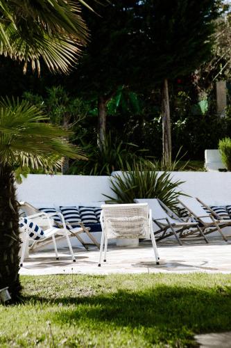 a group of lawn chairs sitting next to a wall at VILLA Centre Guethary piscine acces ocean a pied in Guéthary