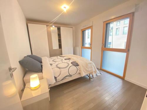 une chambre avec un lit et une grande fenêtre dans l'établissement Appartement haut standing Paris La Defense Arena, à Nanterre