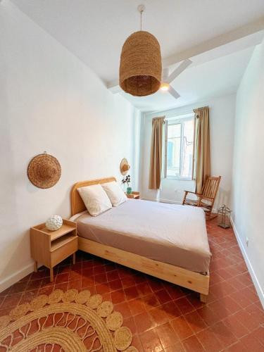 une chambre avec un lit et une chaise dedans dans l'établissement La Cigale - Centre Ville - Wifi, à Cassis