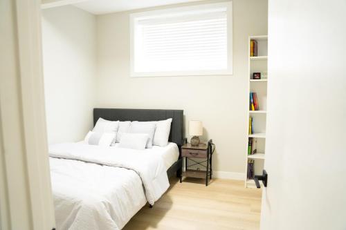 a bedroom with two beds and a window at The Old Trafford - Stylish 2 bed suite in Calgary