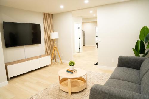 a living room with a couch and a tv at The Old Trafford - Stylish 2 bed suite in Calgary