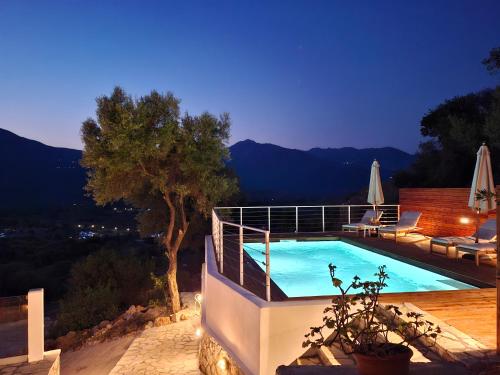 a swimming pool on the side of a house at Pnoes Villas Vasiliki Lefkada in Vasiliki