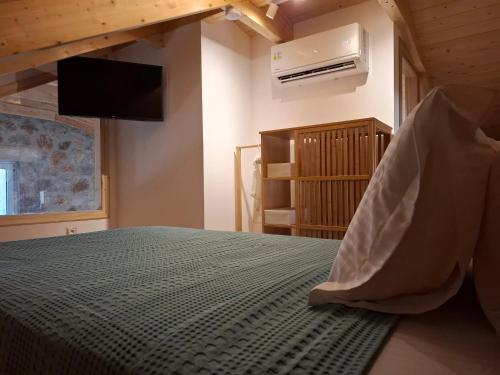a bedroom with a bed with a television and a fan at Pnoes Villas Vasiliki Lefkada in Vasiliki