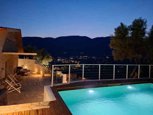a pool on the roof of a house at night at Pnoes Villas Vasiliki Lefkada in Vasiliki