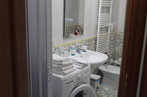 a bathroom with a sink and a washing machine at Luxury Apartment nel Cilento - 10 min da Ascea e mare, WiFi & parcheggio in Castelnuovo Cilento