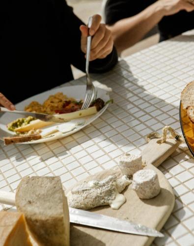 a person holding a fork and knife and a plate of food at VILLA Centre Guethary piscine acces ocean a pied in Guéthary