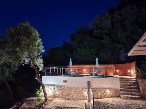 a villa with a swimming pool at night at Pnoes Villas Vasiliki Lefkada in Vasiliki