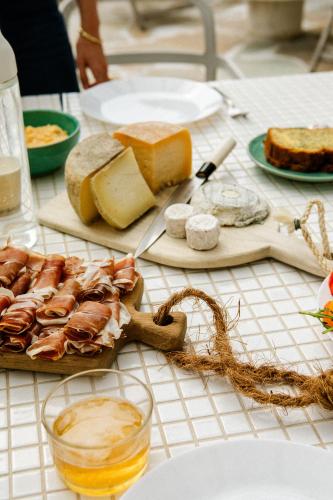 a table topped with cheese and meats and bread at VILLA Centre Guethary piscine acces ocean a pied in Guéthary