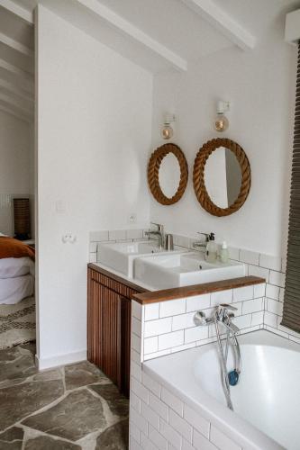 a bathroom with a tub and a sink and mirror at VILLA Centre Guethary piscine acces ocean a pied in Guéthary
