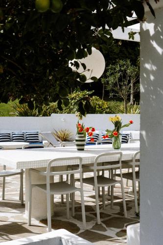 a white table with chairs and vases on it at VILLA Centre Guethary piscine acces ocean a pied in Guéthary