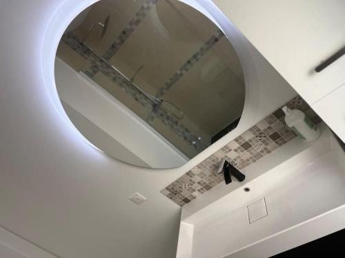 une salle de bain avec un miroir et un lavabo dans l'établissement Maison Bel Air, à La Rochelle