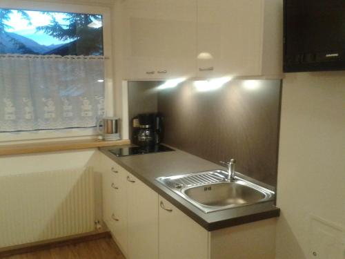 a kitchen with a stainless steel sink and a window at Apartment Valtiner in Sankt Anton am Arlberg