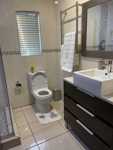 a bathroom with a toilet and a sink at TG Villa Menlyn in Pretoria