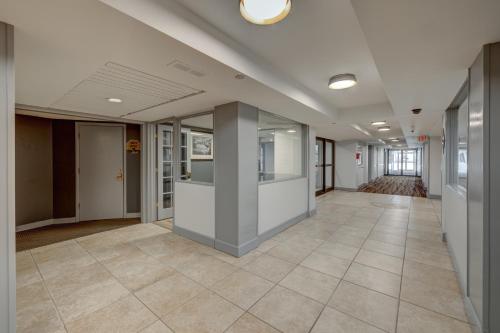 an empty hallway in a building with a tile floor at Riverside Hotel in Casper