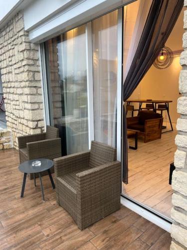 - une véranda avec 2 chaises et une table dans l'établissement Maison Bel Air, à La Rochelle