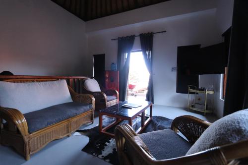 a living room with couches and a table and a tv at Bali at Scenic Haven Lodge in Hartbeespoort in Hartbeespoort