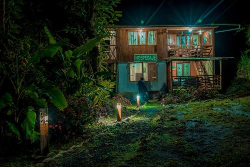 a person standing in front of a house at night at Balcón Tumpiki in Pedro Vicente Maldonado