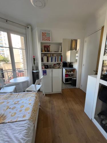 une chambre avec un lit et une table et une cuisine dans l'établissement Joli appartement près de Montmartre, à Paris