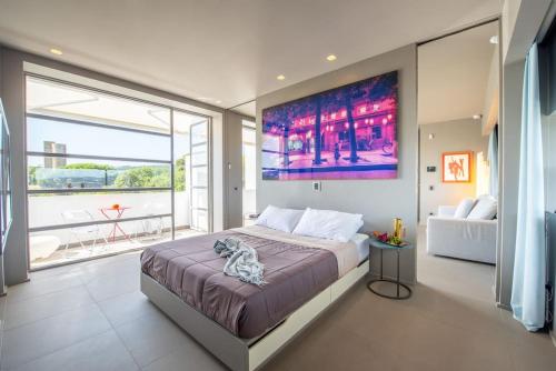 une chambre avec un grand lit et une grande fenêtre dans l'établissement Saint Tropez en style! Chic & central, à Saint-Tropez