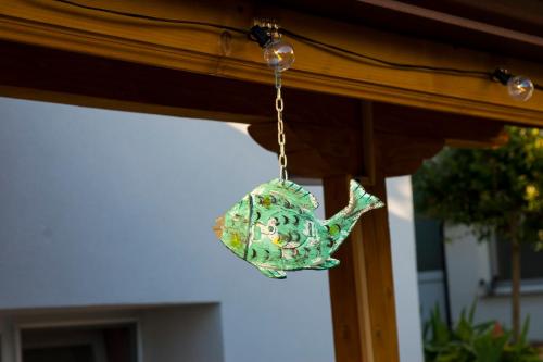 a green glass teapot hanging from a table at Къща за гости Ози in Ovchartsi