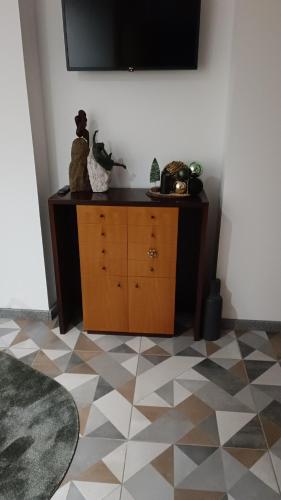 a room with a dresser with a television on a wall at Cachinnans Hostel & apartaments in Vila do Conde