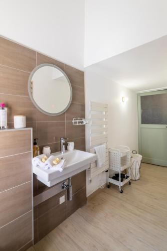 une salle de bain avec un lavabo et un miroir dans l'établissement T2 Climatisé de charme, pour couple proche Arènes MaisonCarréeConciergerie, à Nîmes