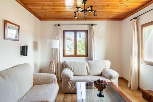 a living room with two white couches and a table at Casa Los Mozos, a 9 kilómetros de Santander y a 6 de Cabárceno in El Astillero