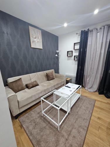 a living room with a couch and a table at Appartement 10 min de stade de France et 15 min de airport CDG in La Courneuve