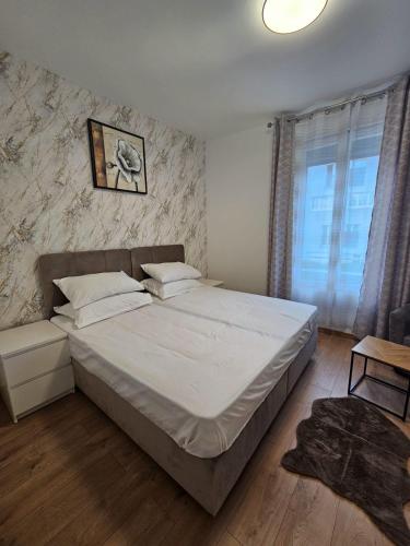 une chambre avec un grand lit et une fenêtre dans l'établissement Appartement 10 min de stade de France et 15 min de airport CDG, à La Courneuve