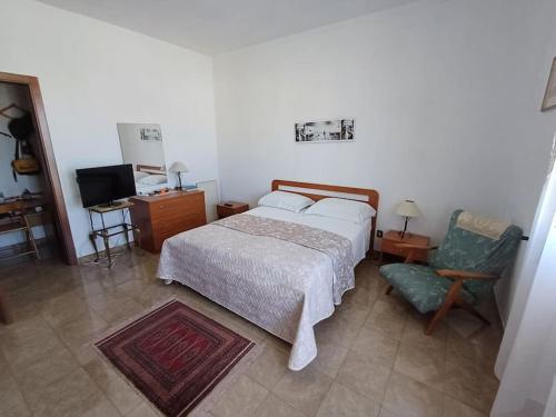 una camera con letto, sedia e televisore di Casa Arcamaria - Appartamento ad Avetrana