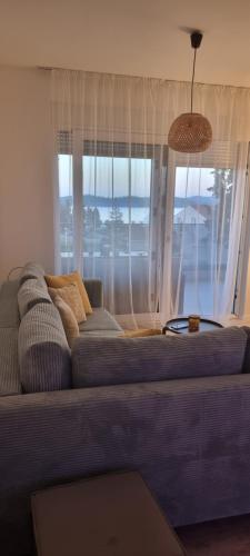 a couch in a living room with a large window at Summer Park Residence Peljesac in Orebić