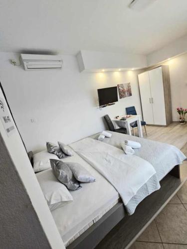 a bedroom with two beds with pillows and a tv at Cube Gray in Mostar