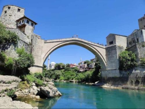 an old bridge over a river in a city at Cube Gray in Mostar