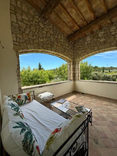 une chambre avec un lit et une grande fenêtre dans l'établissement Chambre d'hôte au cœur de la Provence Eygalieres, à Eygalières