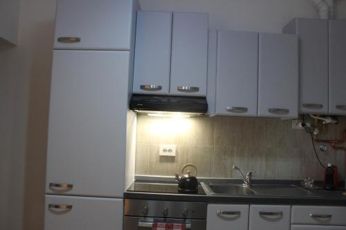 a kitchen with white cabinets and a sink at Blue Home in Pero