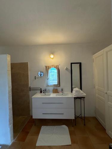 une salle de bain avec un lavabo blanc et un miroir dans l'établissement Chambre d'hôte au cœur de la Provence Eygalieres, à Eygalières