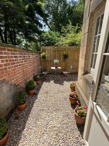 a courtyard with potted plants on the side of a house at The Motor House in Newcastle upon Tyne