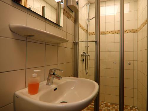 a bathroom with a sink and a bottle of soap at Alt Krassow Lakeside Retreat in Krassow