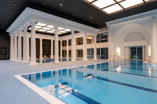 a large swimming pool in a building with a ceiling at Kúpele Brusno - Kúpeľný hotel Poľana in Brusno