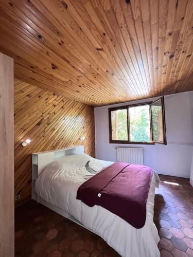 une chambre avec un grand lit avec un plafond en bois dans l'établissement Maison avec espace cinéma, à Le Plessis-Trévise