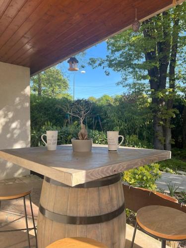 une table avec deux tasses au-dessus d'un tonneau dans l'établissement Maison avec espace cinéma, à Le Plessis-Trévise