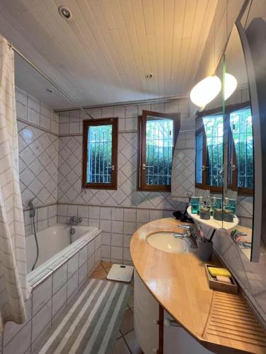 une salle de bain avec une baignoire et un lavabo et une baignoire dans l'établissement Maison avec espace cinéma, à Le Plessis-Trévise