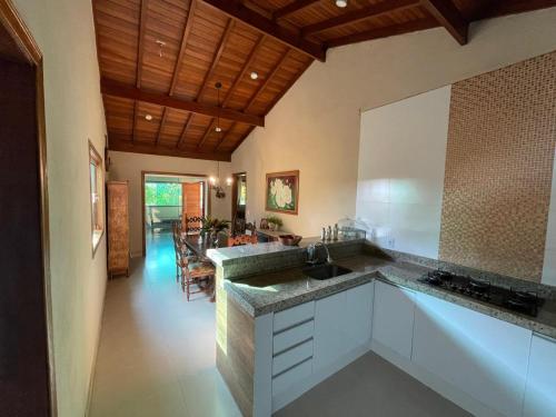 a kitchen with a sink and a dining room at Chácara Recanto da família in Jacutinga